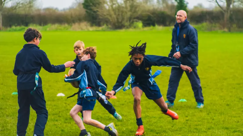 Pupils playing tag rugby on the school field